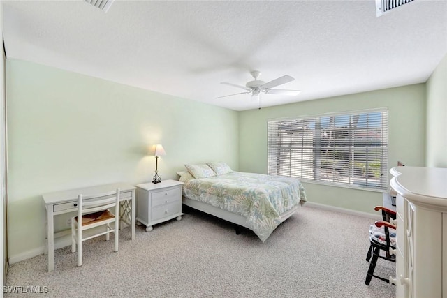 bedroom with baseboards, visible vents, light colored carpet, ceiling fan, and a textured ceiling