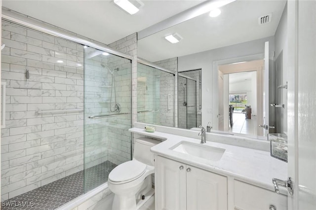 bathroom featuring a stall shower, visible vents, vanity, and toilet