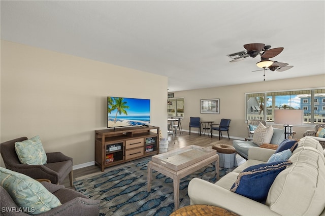 living room featuring visible vents, wood finished floors, a ceiling fan, and baseboards