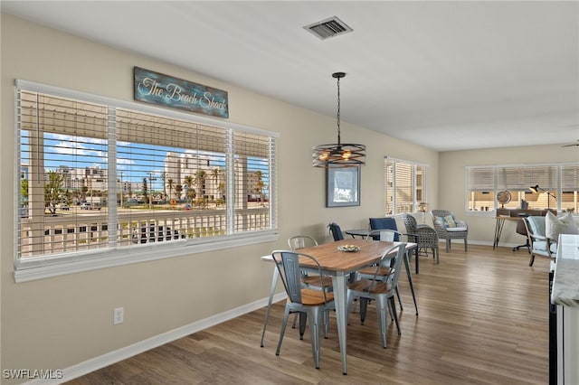 dining space featuring visible vents, baseboards, and wood finished floors