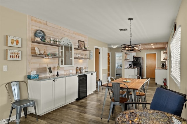 dining room featuring wine cooler, visible vents, and dark wood-type flooring