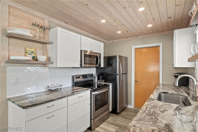 kitchen featuring open shelves, stainless steel appliances, backsplash, white cabinetry, and a sink