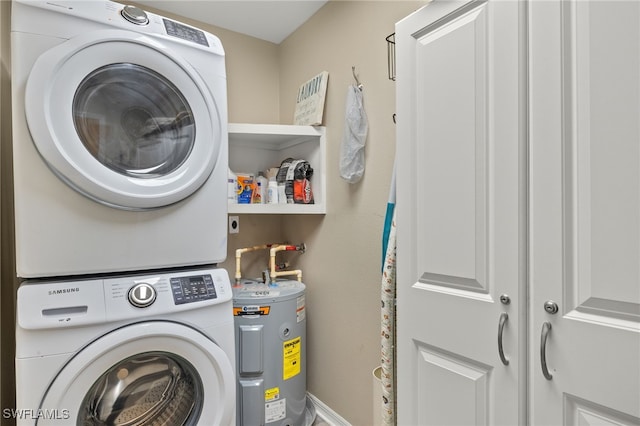 washroom featuring laundry area, water heater, and stacked washer / dryer