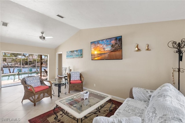 living room with tile patterned flooring, visible vents, lofted ceiling, and baseboards