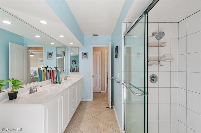 bathroom featuring double vanity, a stall shower, tile patterned flooring, and a sink