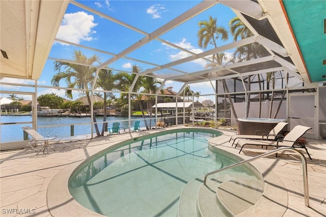 pool featuring glass enclosure, a patio area, a water view, and a hot tub