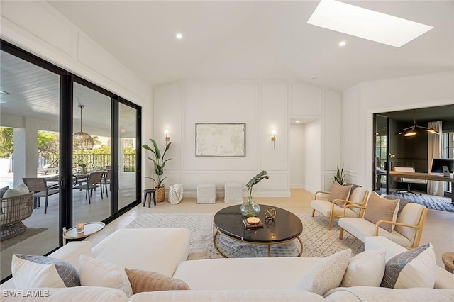 living room with lofted ceiling with skylight, recessed lighting, and a decorative wall