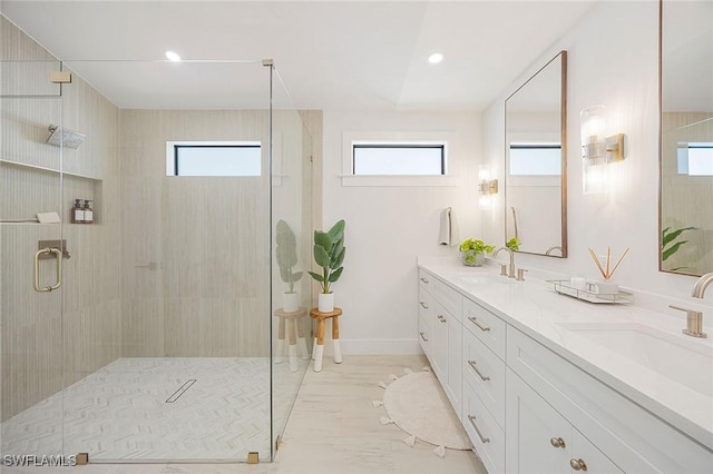 bathroom featuring a healthy amount of sunlight, a sink, and a shower stall