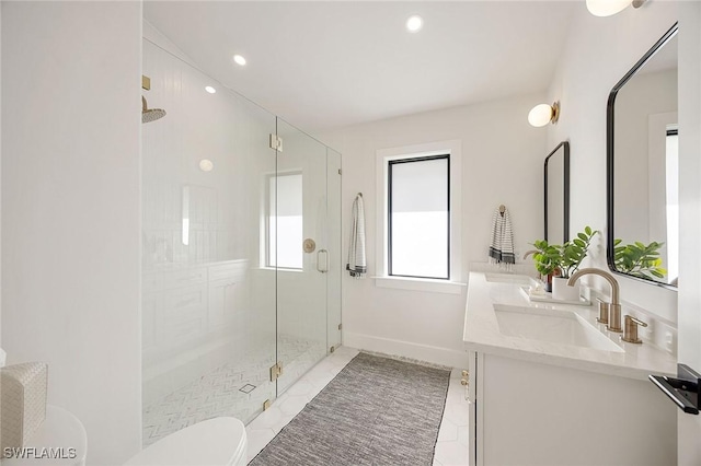 bathroom with double vanity, toilet, a sink, a shower stall, and baseboards