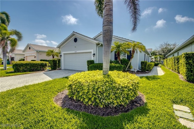 single story home with driveway, stucco siding, a garage, and a front yard