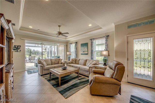 living area with baseboards, light tile patterned flooring, a raised ceiling, and crown molding