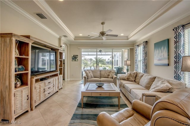 living room featuring light tile patterned floors, visible vents, a raised ceiling, ceiling fan, and crown molding