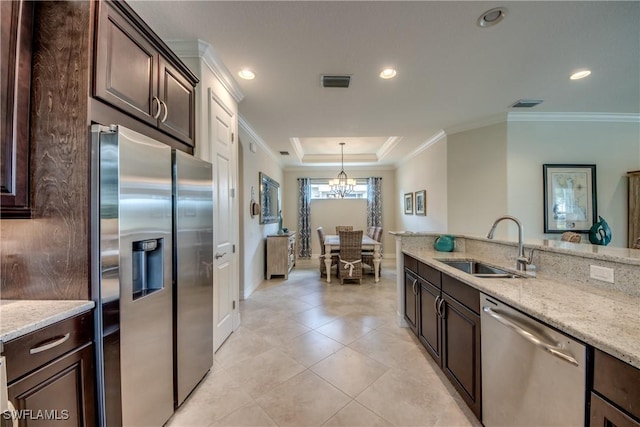 kitchen featuring appliances with stainless steel finishes, crown molding, a sink, and dark brown cabinets