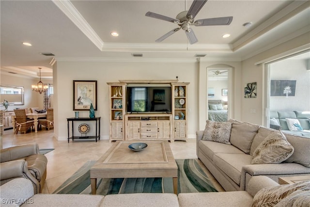 living room with recessed lighting, a raised ceiling, ornamental molding, tile patterned flooring, and ceiling fan with notable chandelier