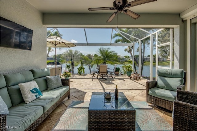 sunroom featuring a water view and ceiling fan