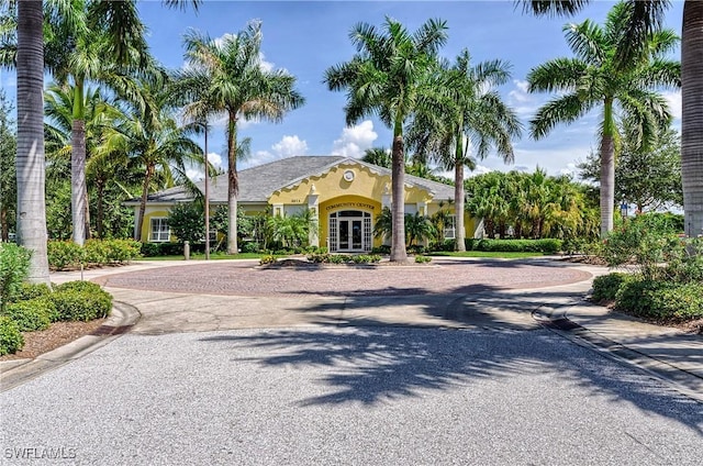 view of front of property with decorative driveway, french doors, and stucco siding