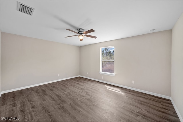 unfurnished room with a ceiling fan, dark wood finished floors, visible vents, and baseboards