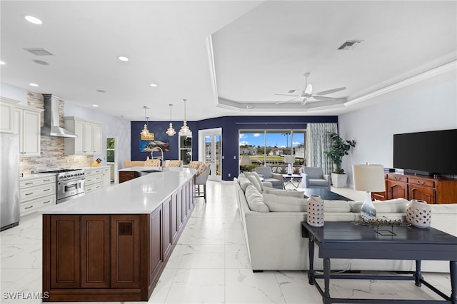 kitchen with visible vents, appliances with stainless steel finishes, marble finish floor, light countertops, and wall chimney range hood