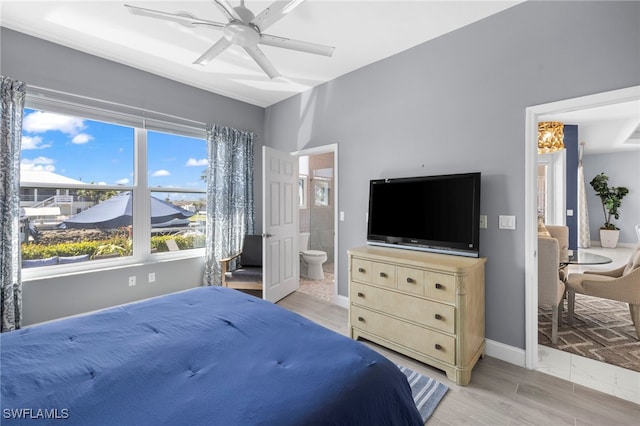 bedroom featuring ceiling fan, light wood-style flooring, baseboards, and ensuite bathroom