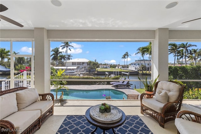 sunroom with a water view and ceiling fan