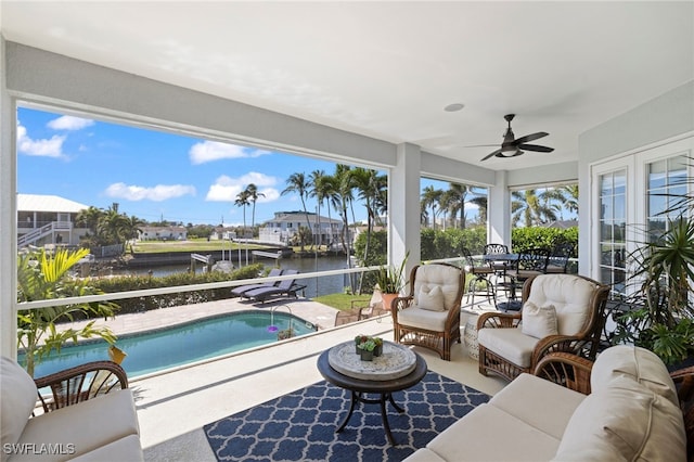 sunroom with a water view and ceiling fan