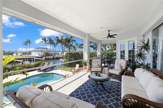 sunroom / solarium featuring a water view and french doors