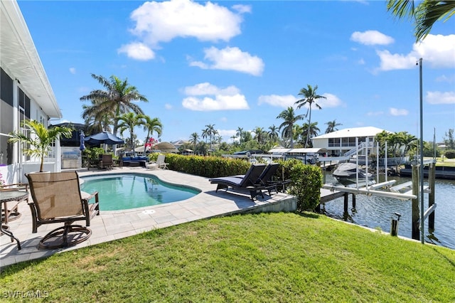 outdoor pool featuring a patio, boat lift, a water view, a yard, and a boat dock