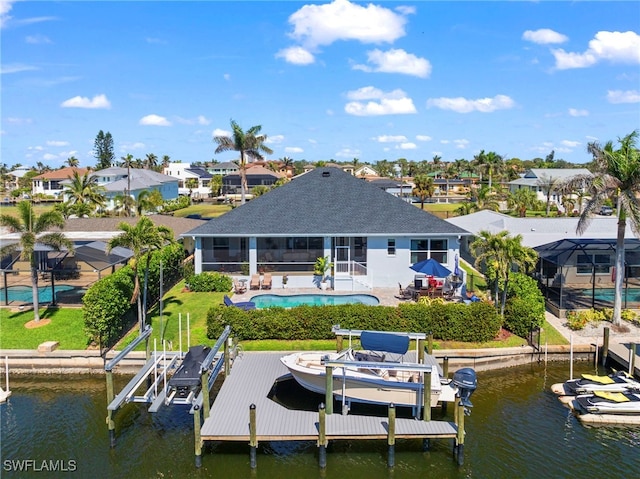 dock area with a water view, glass enclosure, boat lift, and an outdoor pool