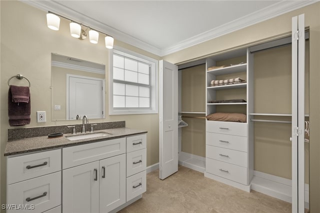 bathroom with ornamental molding, a walk in closet, and vanity