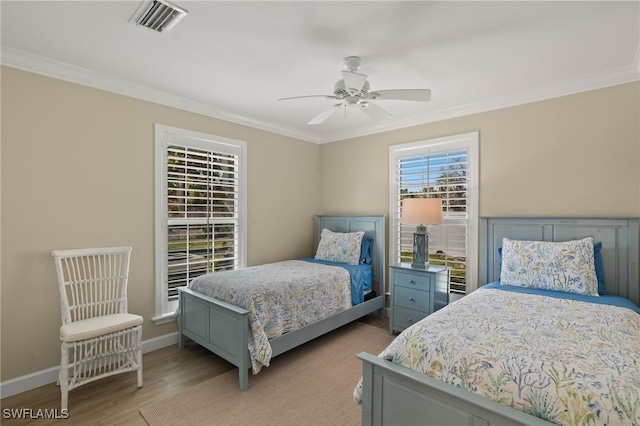 bedroom with ornamental molding, light wood finished floors, visible vents, and baseboards