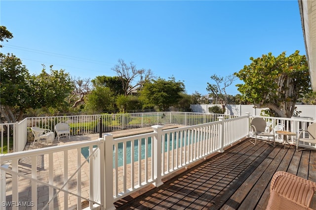 wooden deck featuring a fenced backyard and a fenced in pool