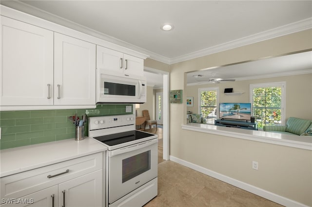 kitchen with white appliances, white cabinets, light countertops, ornamental molding, and tasteful backsplash