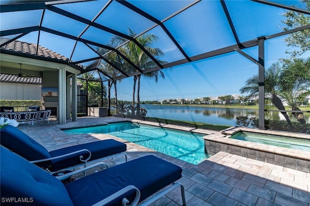 pool with a patio area, a water view, a lanai, and an in ground hot tub