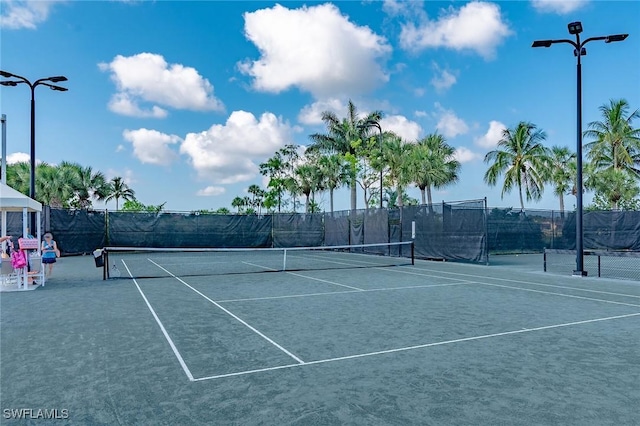 view of tennis court featuring fence