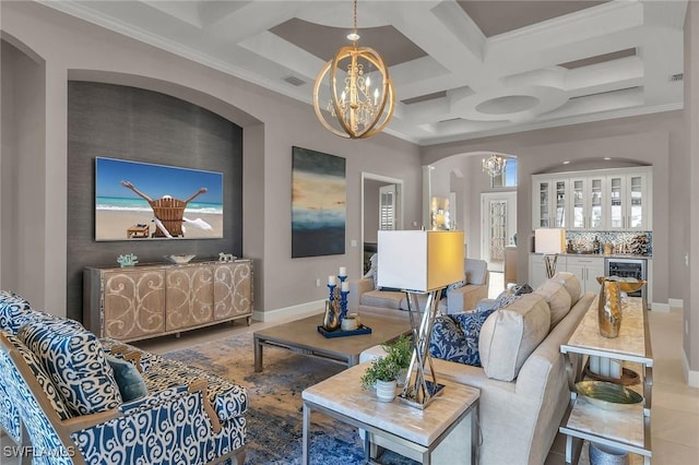 living area with arched walkways, coffered ceiling, a notable chandelier, and baseboards