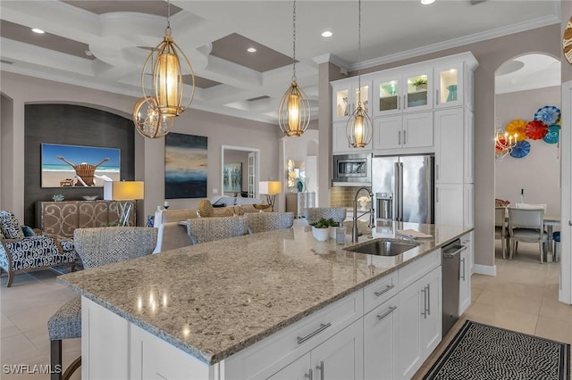 kitchen featuring light tile patterned floors, decorative light fixtures, stainless steel appliances, white cabinetry, and a sink