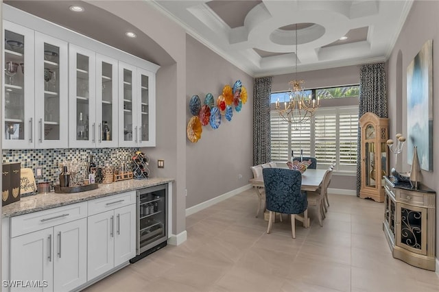 dining area with beverage cooler, coffered ceiling, crown molding, and baseboards