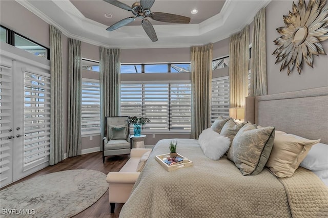 bedroom with ornamental molding, a raised ceiling, and wood finished floors