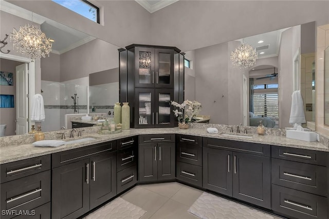 full bathroom with a stall shower, a notable chandelier, ornamental molding, and a sink