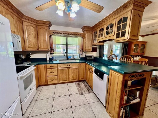 kitchen featuring dark countertops, white appliances, and a sink