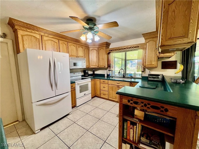 kitchen featuring dark countertops, white appliances, light tile patterned floors, and a sink