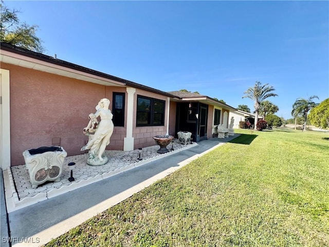 back of property featuring a lawn and stucco siding