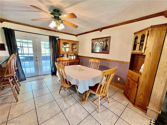 dining space with light tile patterned floors, ceiling fan, ornamental molding, and french doors