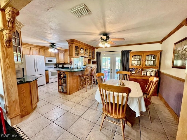 dining area with french doors, light tile patterned floors, visible vents, ornamental molding, and a textured ceiling