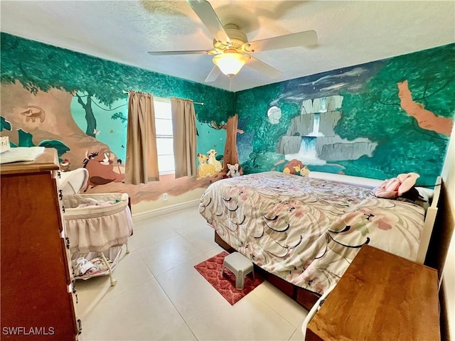 tiled bedroom with ceiling fan, a textured ceiling, baseboards, and wallpapered walls