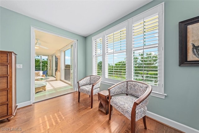 sitting room featuring plenty of natural light, wood finished floors, and baseboards