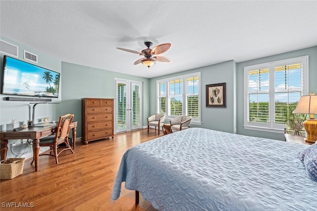 bedroom featuring wood finished floors, visible vents, baseboards, ceiling fan, and access to exterior