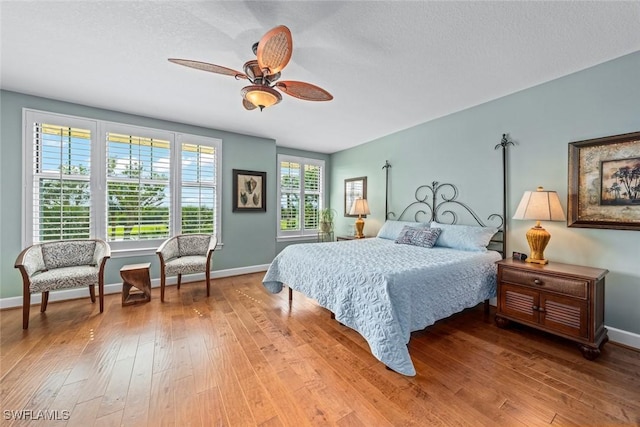 bedroom featuring a ceiling fan, baseboards, and wood-type flooring