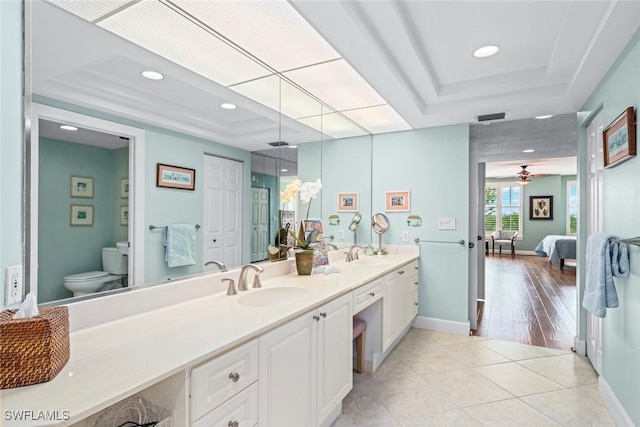 full bath with a sink, a tray ceiling, and visible vents