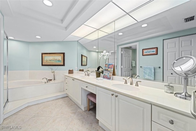 full bathroom with double vanity, a bath, visible vents, and a sink